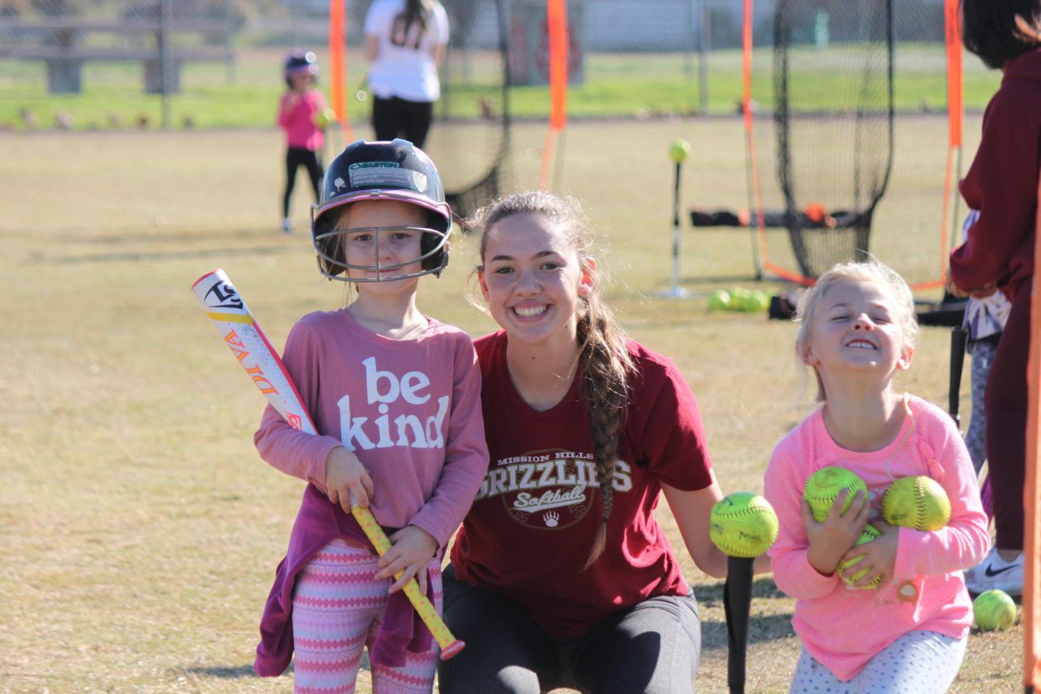 The+softball+team+volunteers+at+a+clinic+to+help+aspiring+young+players