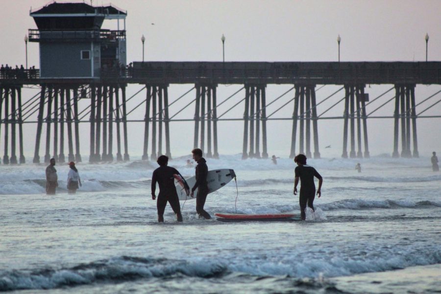 A group of surfers enjoying the waves at Oceanside Pier.