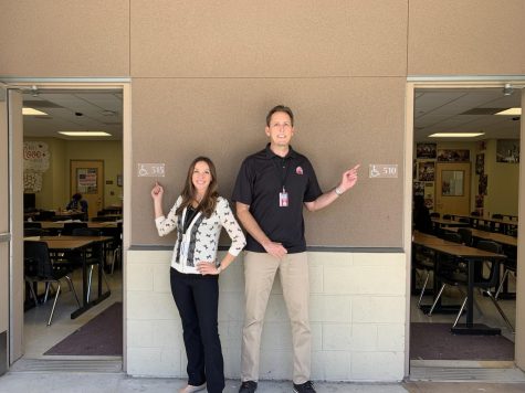 Mr. and Mrs. Miller point to their classrooms that are coincidentally next door.