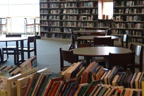 MHHS library filled with book shelves in the back and tables for students to sit at