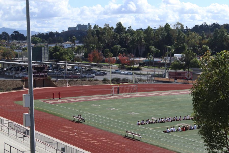 A P.E. class gathers on the Mission Hills football field