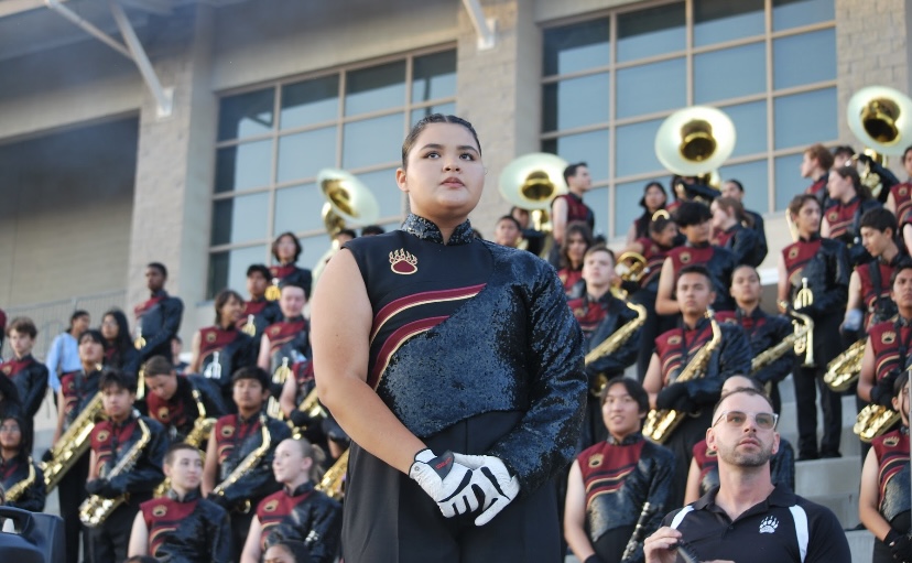 Brenna Tendon watching the football game in search to cues for the band to play their next song.