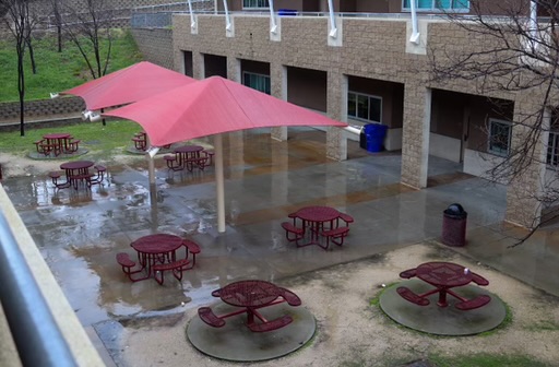 Rainy weather causes lunch tables for students wet, a potential inconvenience.