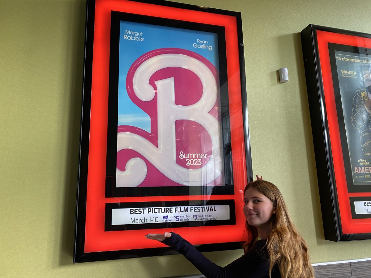 Leah+Henselmeier+stands+next+to+the+Barbie+poster+in+a+Regals+Theater.