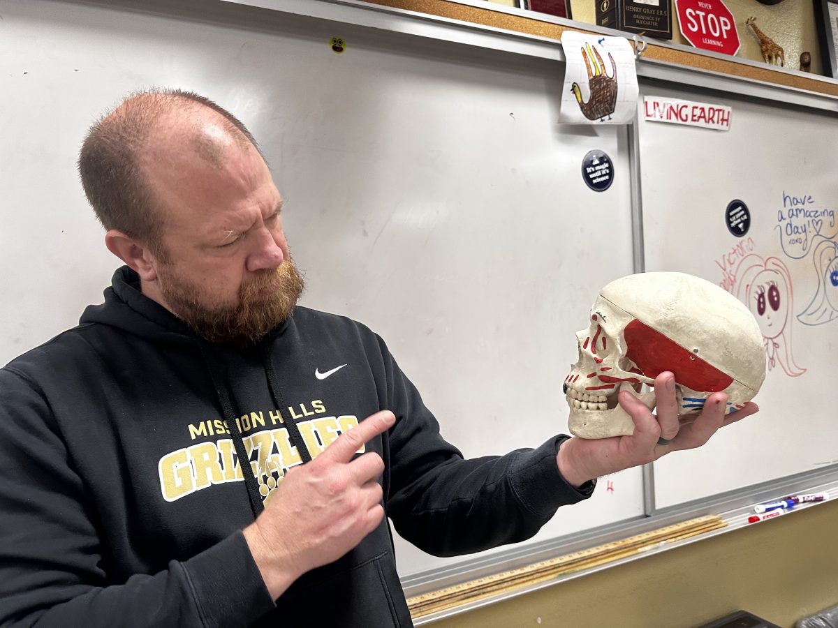 Forensic+Science+teacher+Kevin+Glatt+observes+the+structure+of+the+skull+in+his+hands+while+teaching+students+about+it.