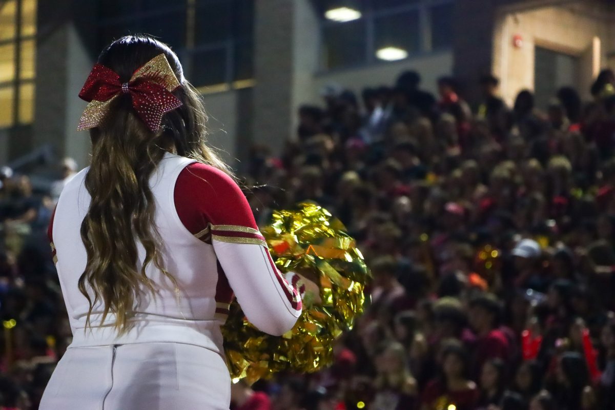 Mission Hills High School cheerleader Lullaby Ballesteros, '26 going through her routine in front of the growl crowd during the first football game of the season, creating excitement and spirit for the event and encouraging the crowd to cheer and participate.